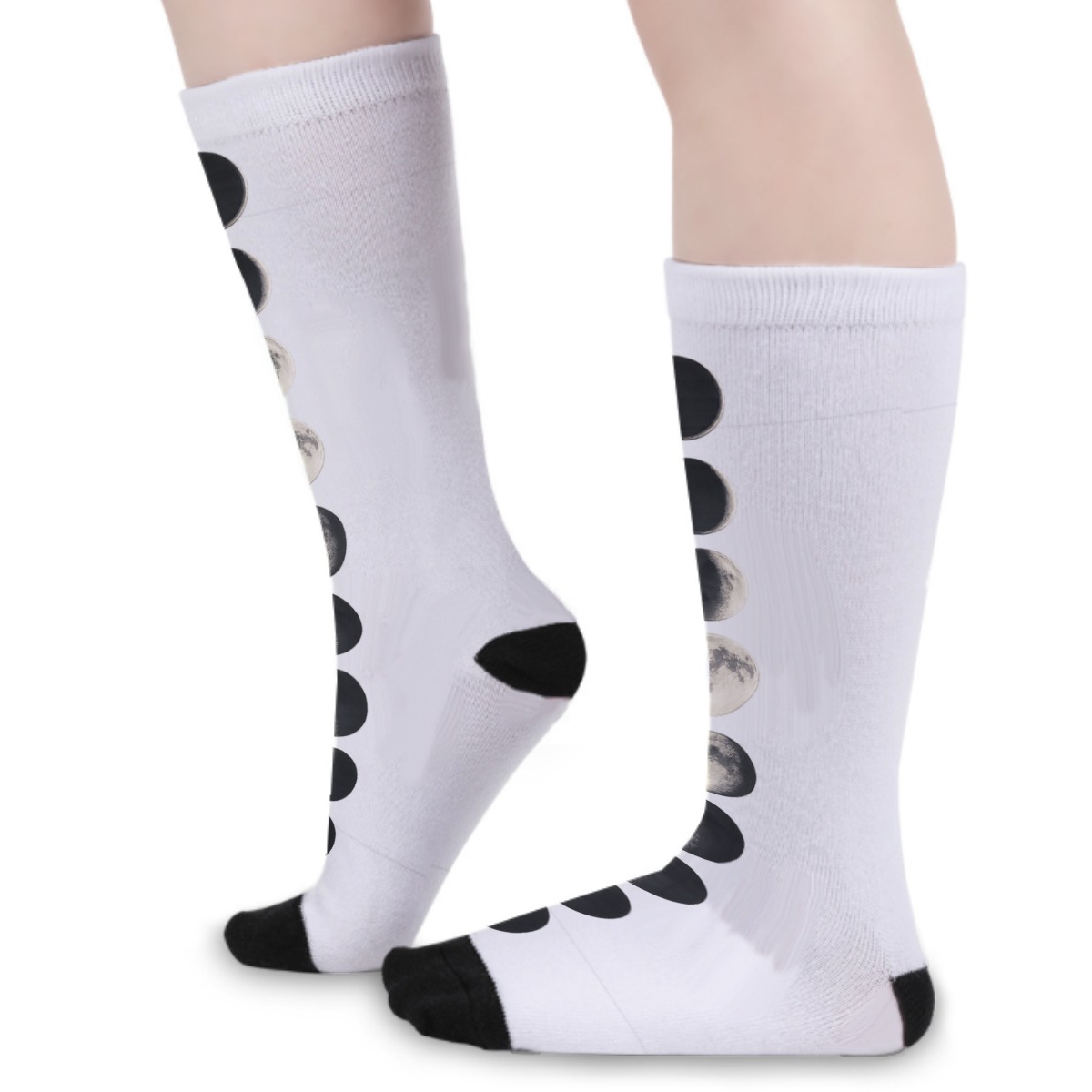 White knee-high socks worn from a side angle with black toe caps and moon phase print.
