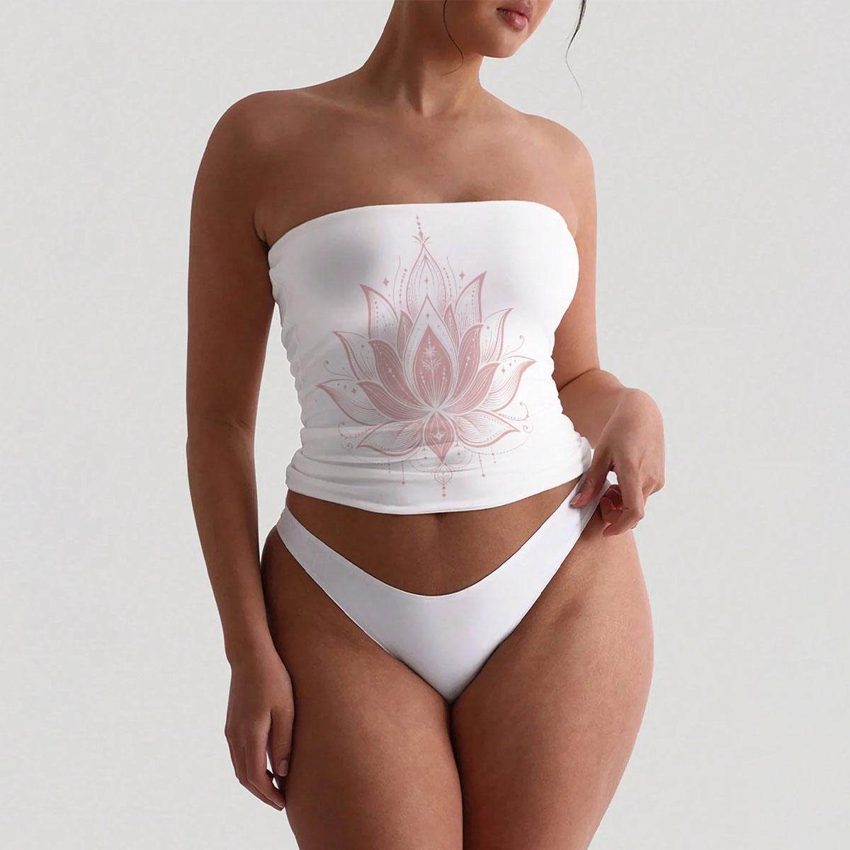 Front view of white bandeau top and matching high-cut bottoms with a pink lotus graphic on the top.