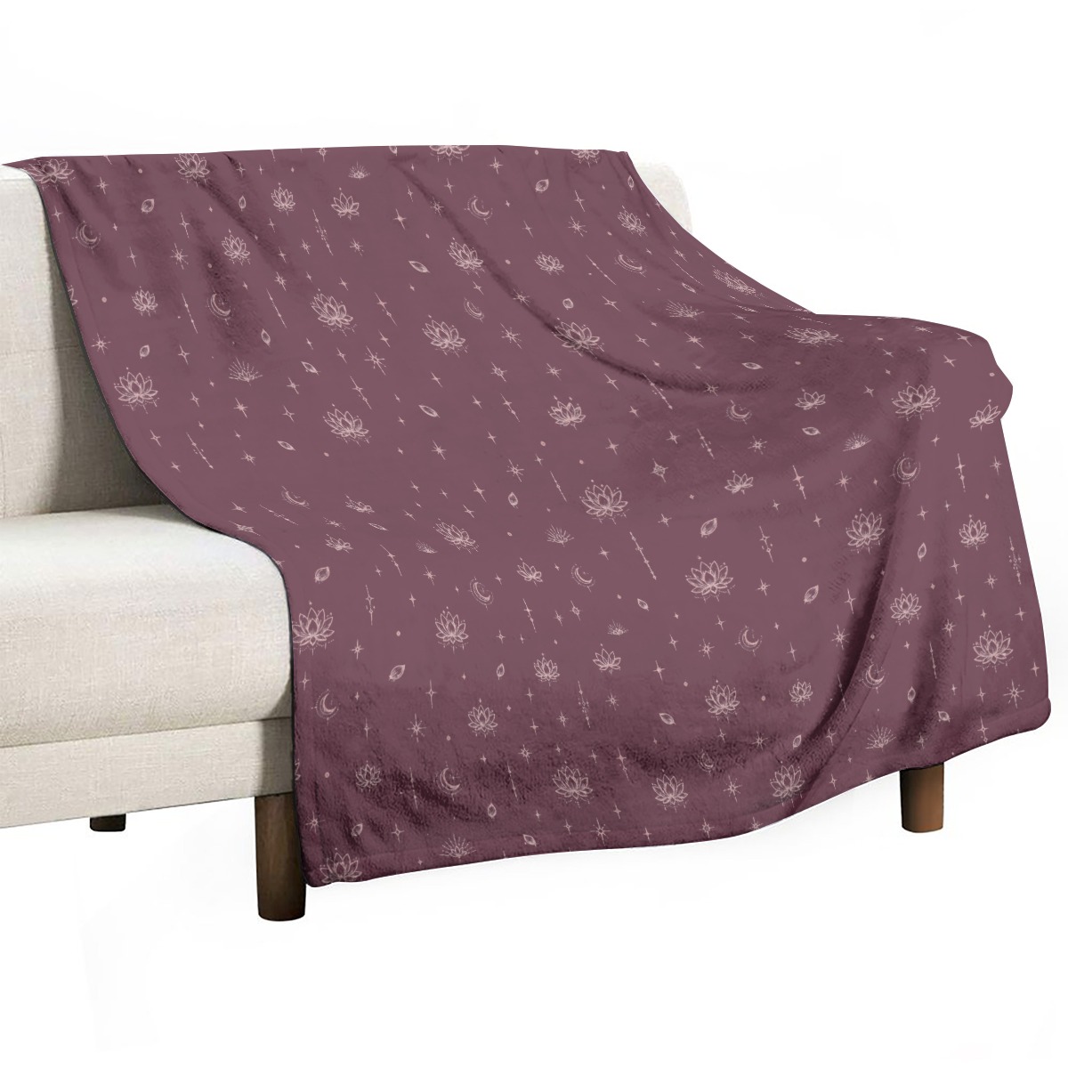 Mauve blanket draped over a light sofa with celestial lotus print