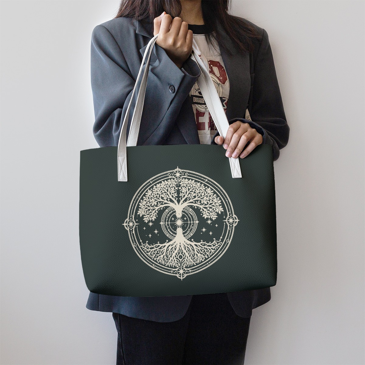 Earthbound Canopy Carryall tote bag worn on shoulder with white straps and tree emblem
